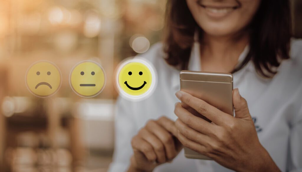 Businesswoman,Pressing,Face,Emoticon,On,Virtual,Touch,Screen,At,Smartphone